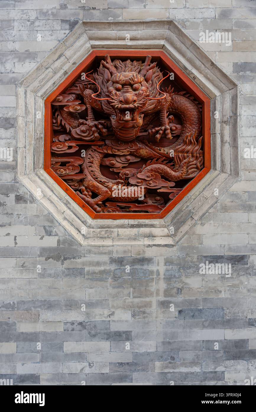 Aufwendige hölzerne Drachenschnitzerei an der Wand eines Gebäudes an der Großen Wildgans-Pagode in Xi'an, China Stockfoto