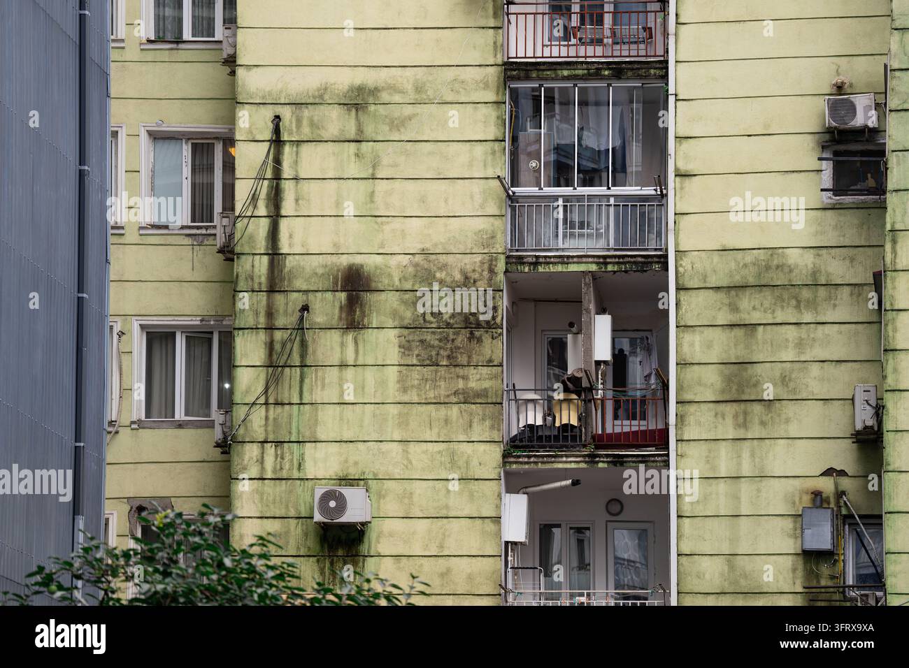 Verwittertes Hausfassade zeigt unsichere Lebensbedingungen, Wasserstau und Rost aufgrund von Feuchtigkeit. Stockfoto
