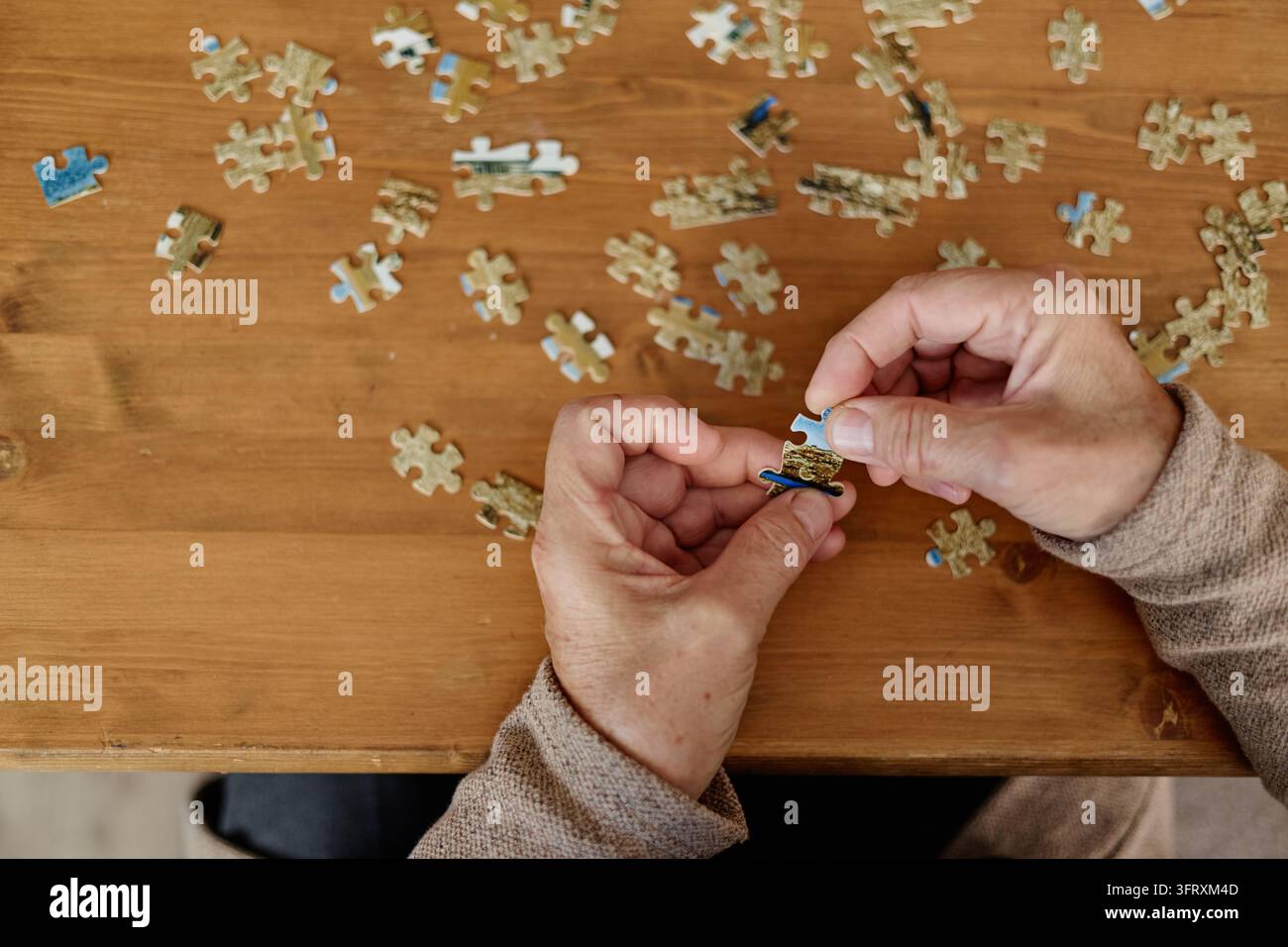 Hände eines Senioren, der ein Puzzle für die Gedächtnispflege zusammenbaut Stockfoto