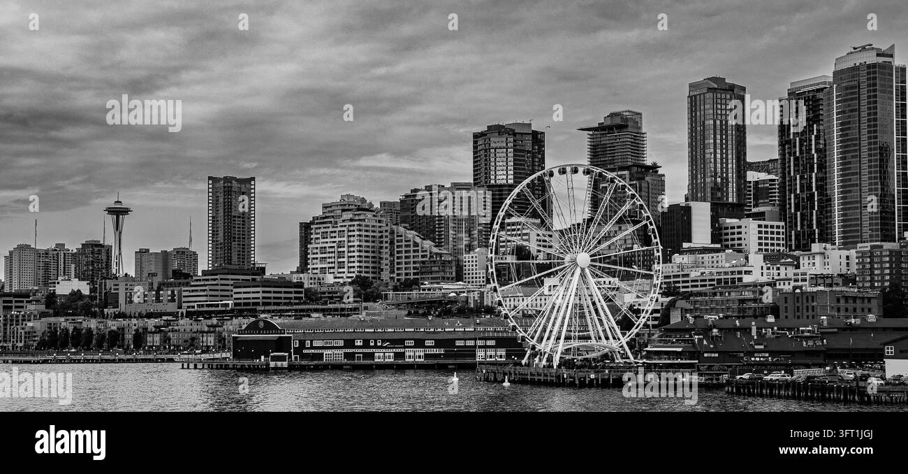Schwarz-weiß-Horizont von Seattle mit dem Space Needle und dem Seattle Great Wheel an der Uferpromenade der Elliott Bay unter einem bewölkten Himmel Stockfoto