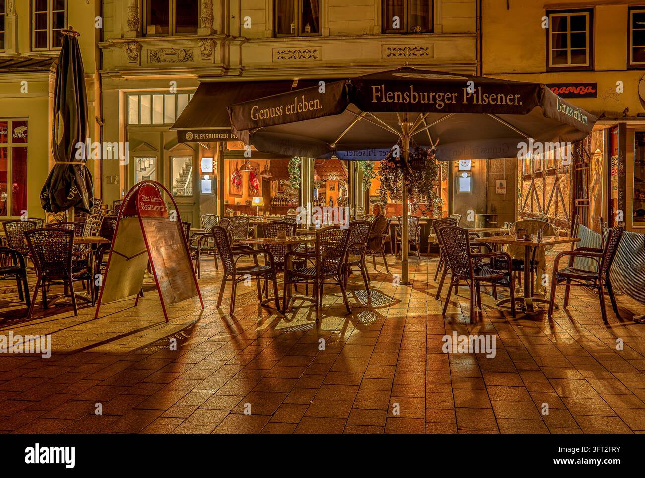 Eine charmante Außenterrasse eines Restaurants bei Nacht in Flensburg, Deutschland, am 15. September 2026 Stockfoto