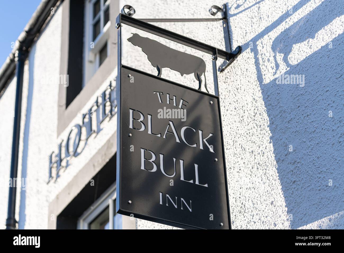 Das Schild des Black Bull Inn Pubs mit einer ausgeschnittenen Bullen-Silhouette auf einer weißen Grobputzwand in Duns, Scottish Borders, Schottland Stockfoto