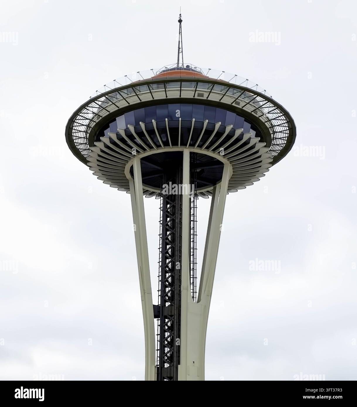 Luftbild des Space Needle-Beobachtungsturms mit seinem ikonischen tellergestaltigen Dach und strukturellen Stützpfeilern vor einem bewölkten Himmel in Seattle, WA Stockfoto
