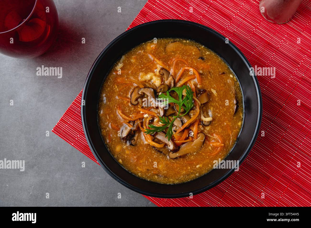Chinesische heiß-saurer Suppe mit Shiitake-Pilzen, Eierbändern und frischen Frühlingszwiebeln Stockfoto