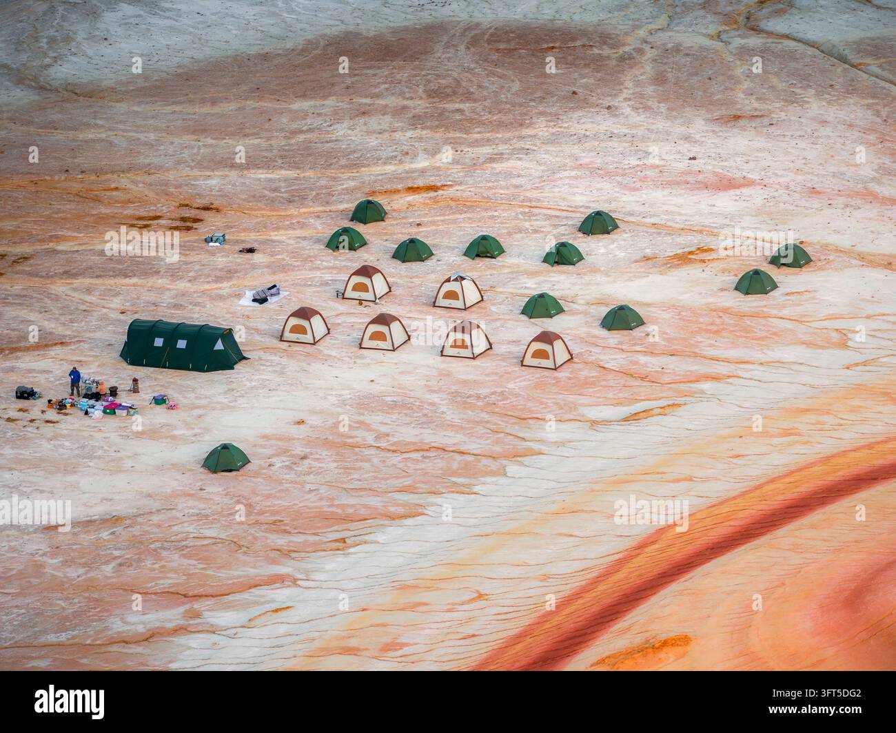Luftbild eines Campingplatzes mit mehreren aufgestellten Zelten auf der einzigartigen rot-weiß geschichteten Landschaft von Kyzyl Kup im Bezirk Karakiya, Region Mangystau Stockfoto