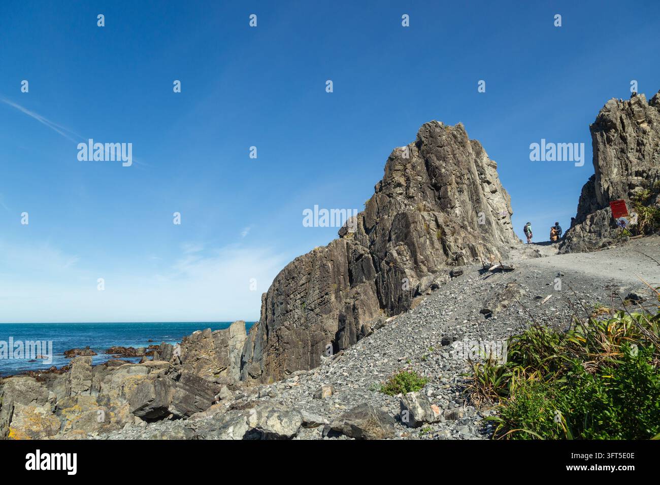 Devil's Gate ist ein schroffer Felsdurchbruch und Wahrzeichen entlang des Red Rocks Coastal Walk (Pariwhero) an der Südküste von Wellington, Neuseeland Stockfoto