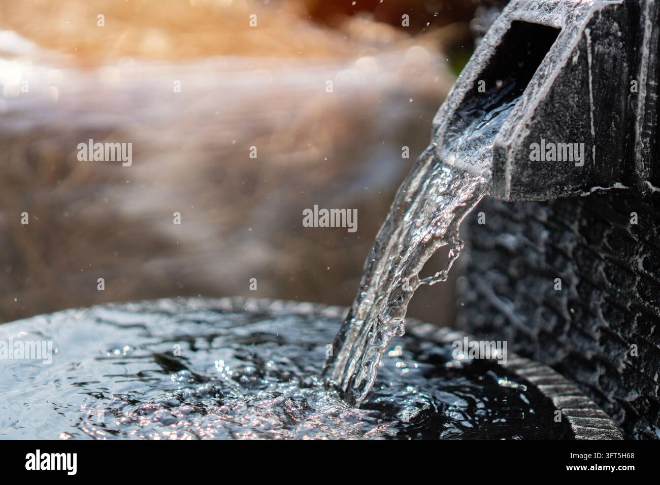 Antike Brunnen im Garten. Nahaufnahme von Wasser, das aus einem Steinbrunnen fließt. Design des antiken Brunnens. Brunnen, Gartendekorationskonzept. Stockfoto