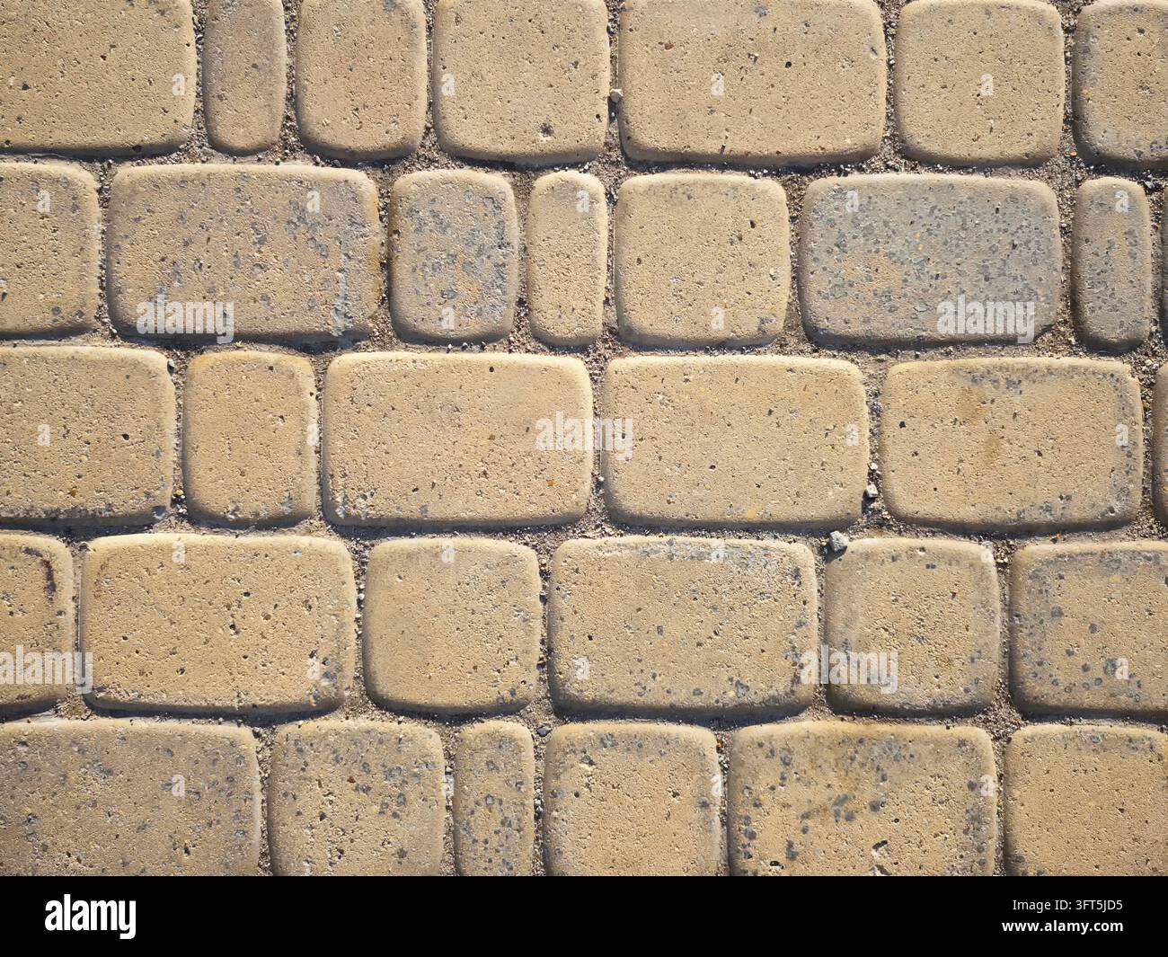 Der Boden, der mit rechteckigen Pflastersteinen bedeckt ist, bietet eine haltbare Oberfläche in einem städtischen Außenbereich. Stockfoto