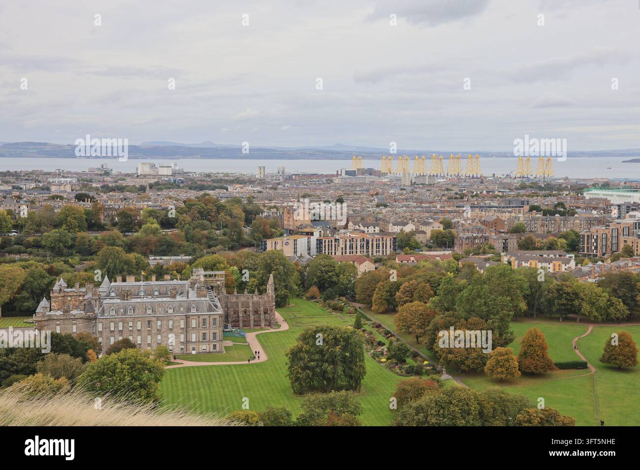 Holyrood Palace und Offshore-Windpark-Bojen im Hafen von Leith, gesehen von den Salisbury Crags in Edinburgh, Schottland, Oktober 2026 Stockfoto