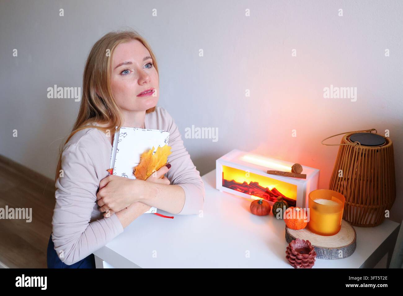 Entspannte Frau mit Kaffee neben einem offenen Tagebuch, ideal für psychische Gesundheit, Achtsamkeit und therapeutische Schreibkampagnen. Stockfoto