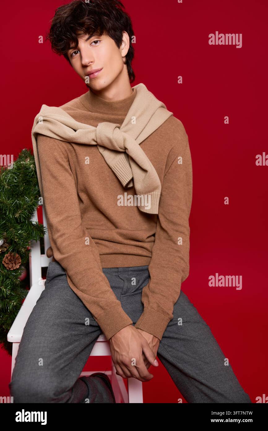 Ein junger Mann genießt die festliche Weihnachtsstimmung in einer warmen Studioatmosphäre Stockfoto