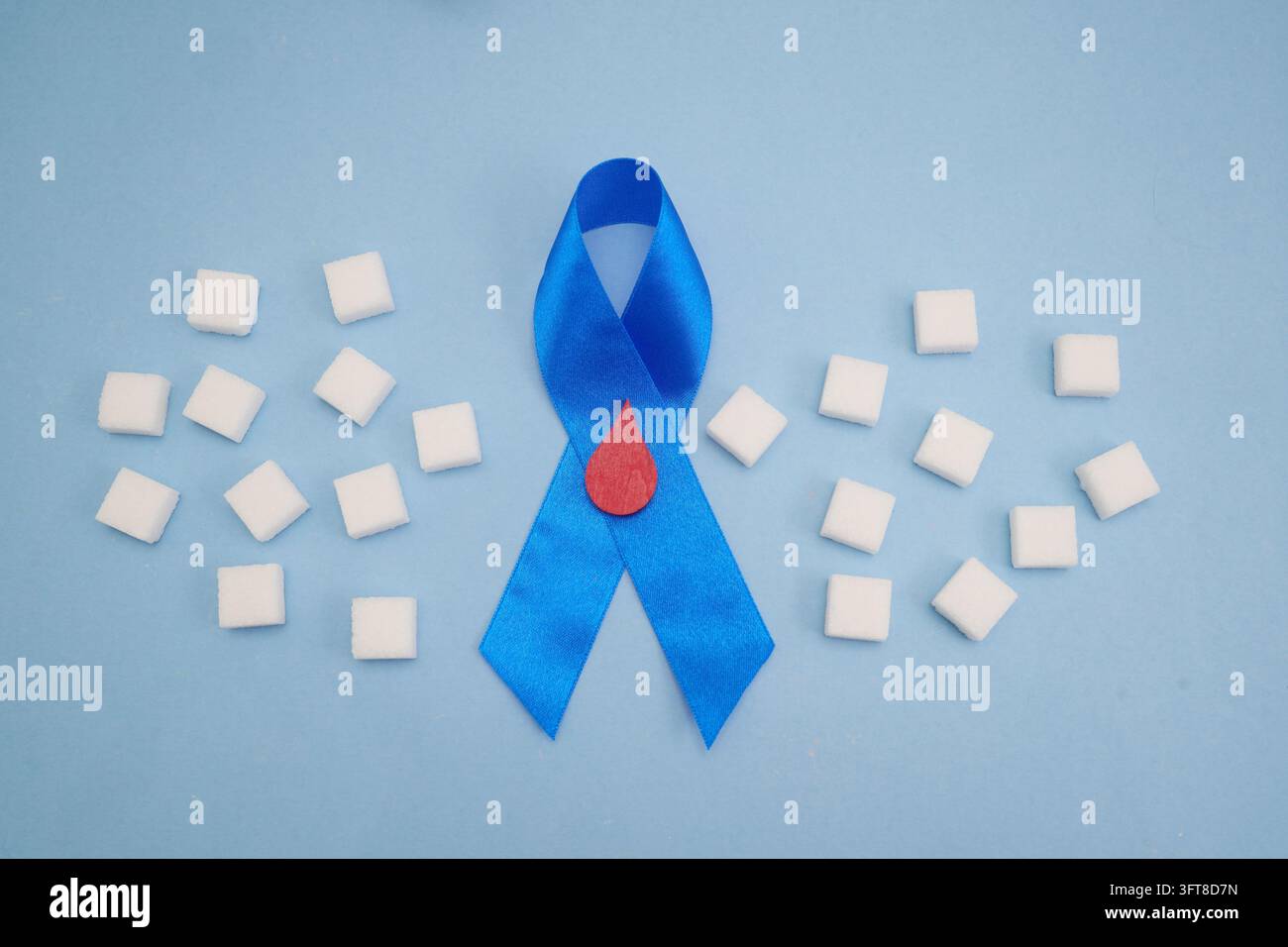 Blaues Band mit Blutstropfen und Zuckerwürfeln für Diabetes-Bewusstseinsarbeit Stockfoto