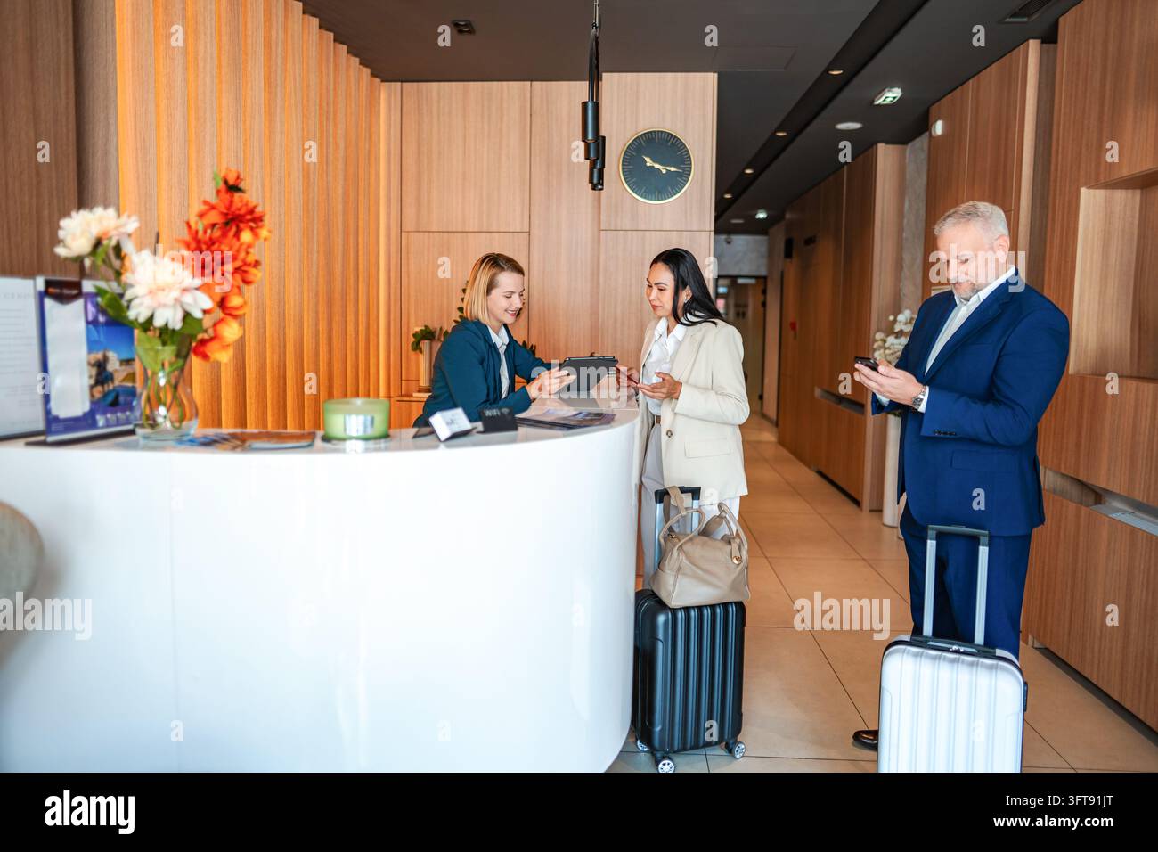 Gäste, die an der modernen Hotelrezeption einchecken Stockfoto