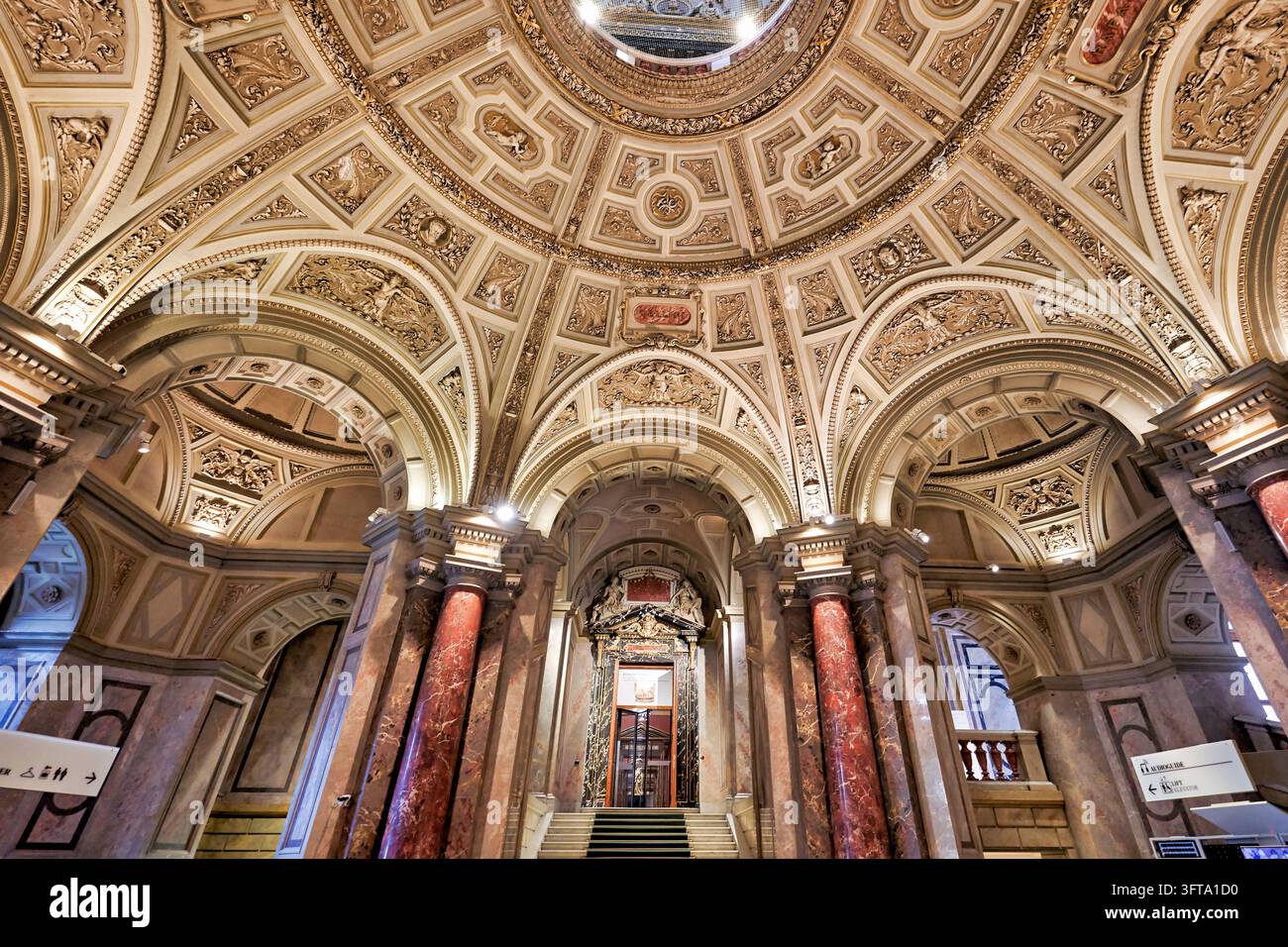 Niedrigwinkelaufnahme von vergoldeten Stuckgewölben, Bögen und roten Marmorsäulen, die eine Treppe in der kaiserlichen Galerie aus dem 19. Jahrhundert an der Ringstraße einrahmen Stockfoto