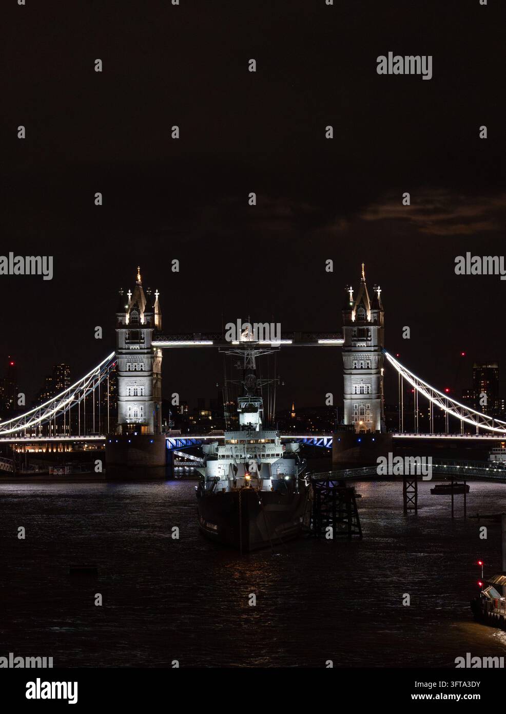 Vertikale Ansicht der Tower Bridge bei Nacht über dem dunklen Fluss Thames, London, UK Stockfoto