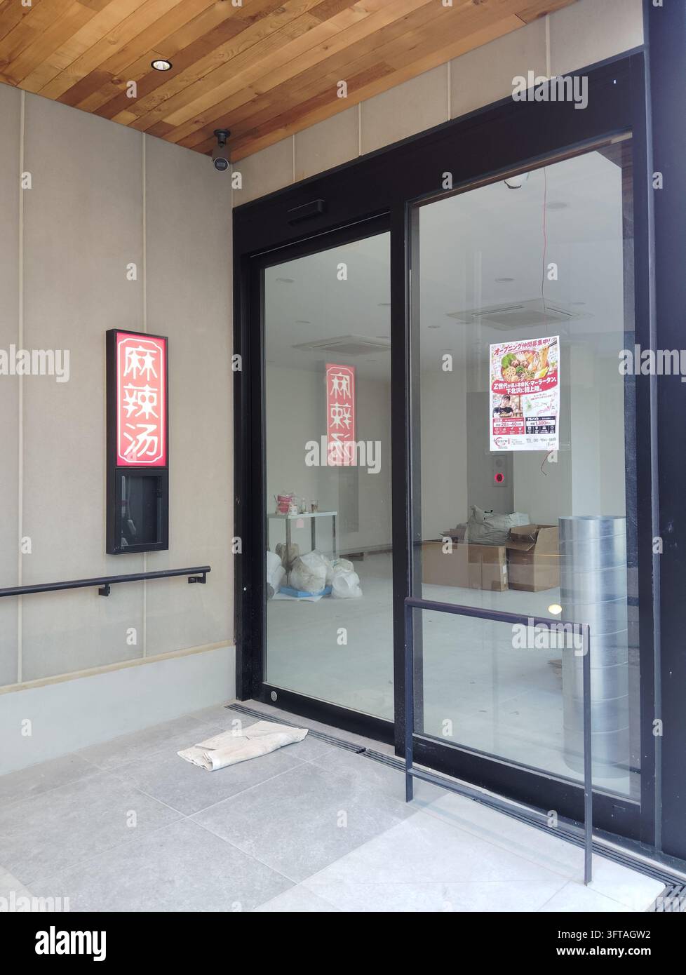 Neues Malatang-Restaurant, das sich auf die Eröffnung vorbereitet, mit einer Eröffnungsansage und sichtbaren Vorräten im Inneren, in Tokio, Japan. - Smartphone-aufgenommenes Stockfoto