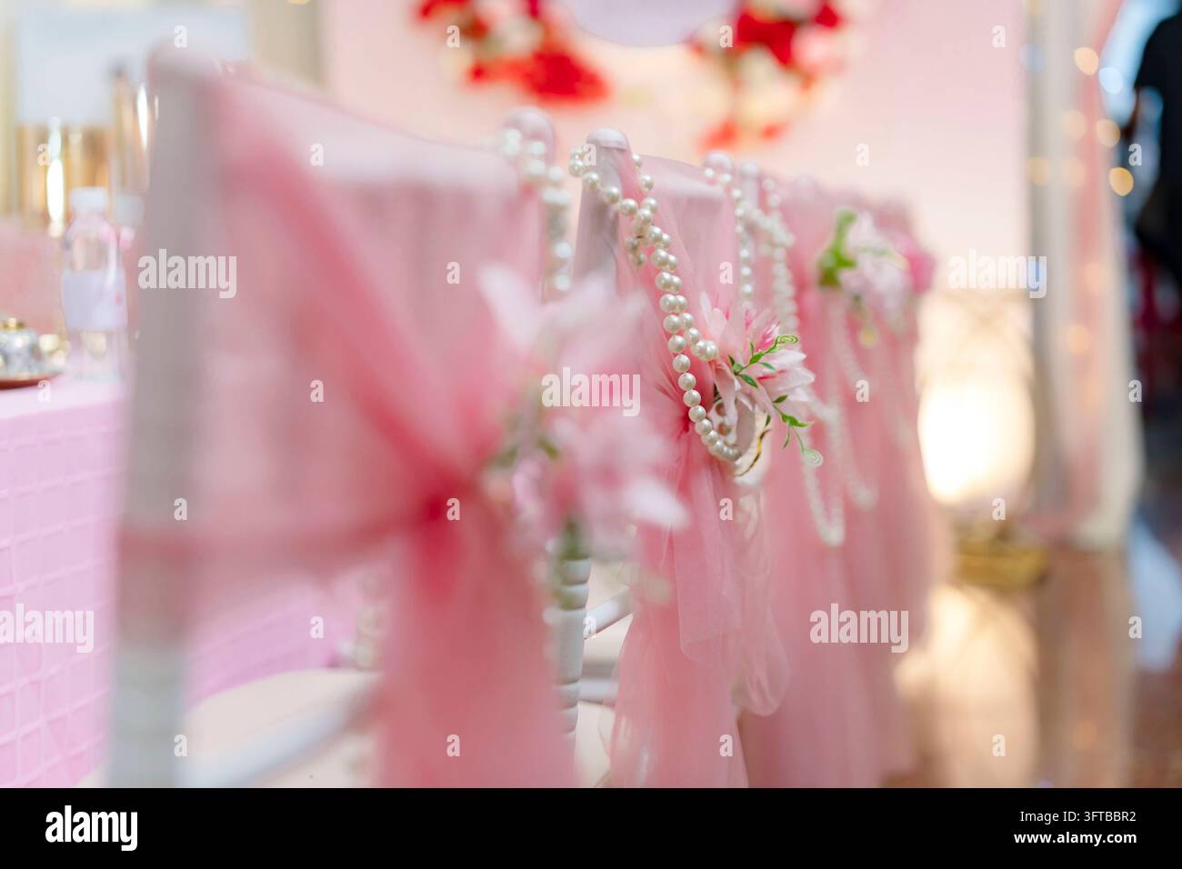 Rosa Tüll- und Perlenperlen-dekorierte Hochstuhlstühle Nahaufnahme Stockfoto
