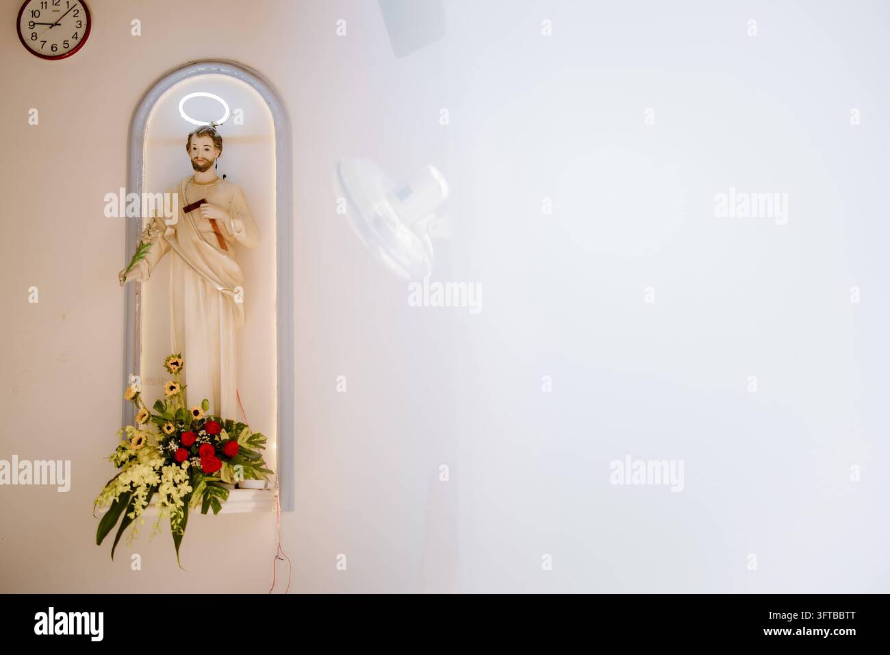 Statue des Heiligen Josef mit dem Jesuskind in einer beleuchteten Nische Stockfoto
