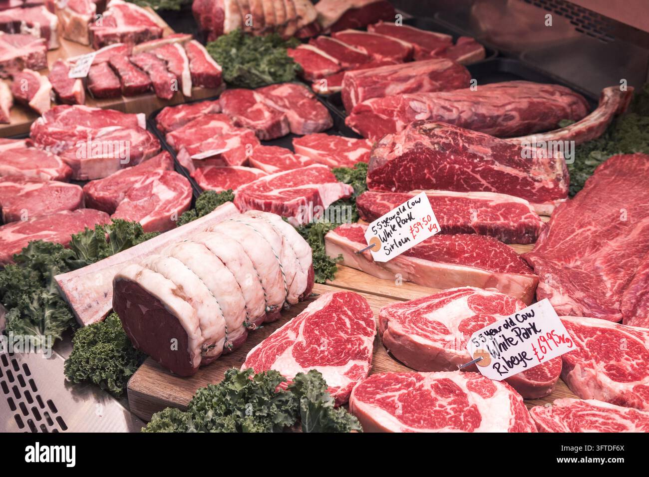 Rohe Rindersteaks und Braten in einer Fleischertheke auf einem Lebensmittelmarkt, London, UK Stockfoto