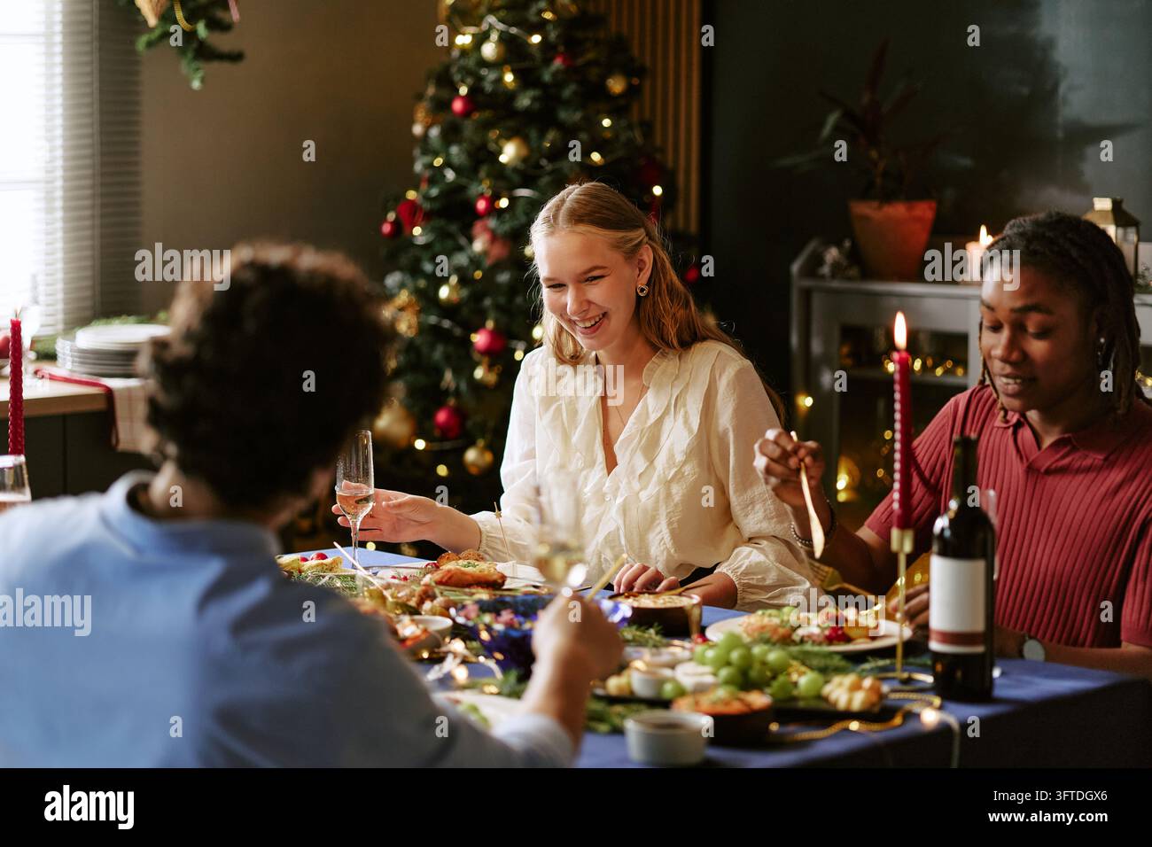 Multikulturelle Freunde feiern das Weihnachtsessen am Esstisch Stockfoto