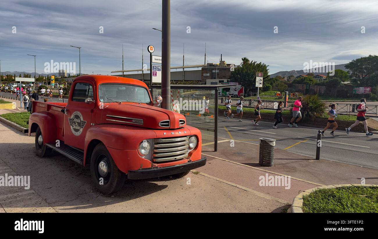 Marseille, Frankreich, 11. Oktober 2026, ein roter Ford F-Pickup, der neben einigen Läufern geparkt ist, die an der 42. Auflage der Course Algernon teilnehmen Stockfoto