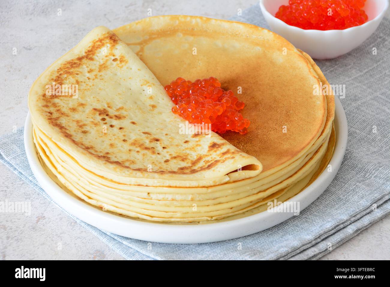 Crêpes mit rotem Kaviar auf dem Teller serviert, Nahaufnahme Stockfoto