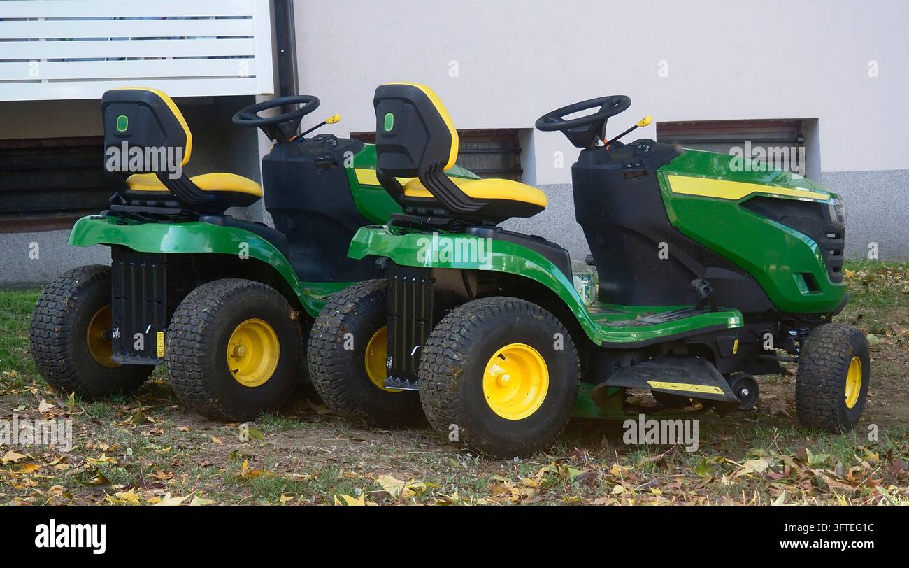 Zwei Reit-Gartenmaschinen, die nebeneinander geparkt sind Stockfoto