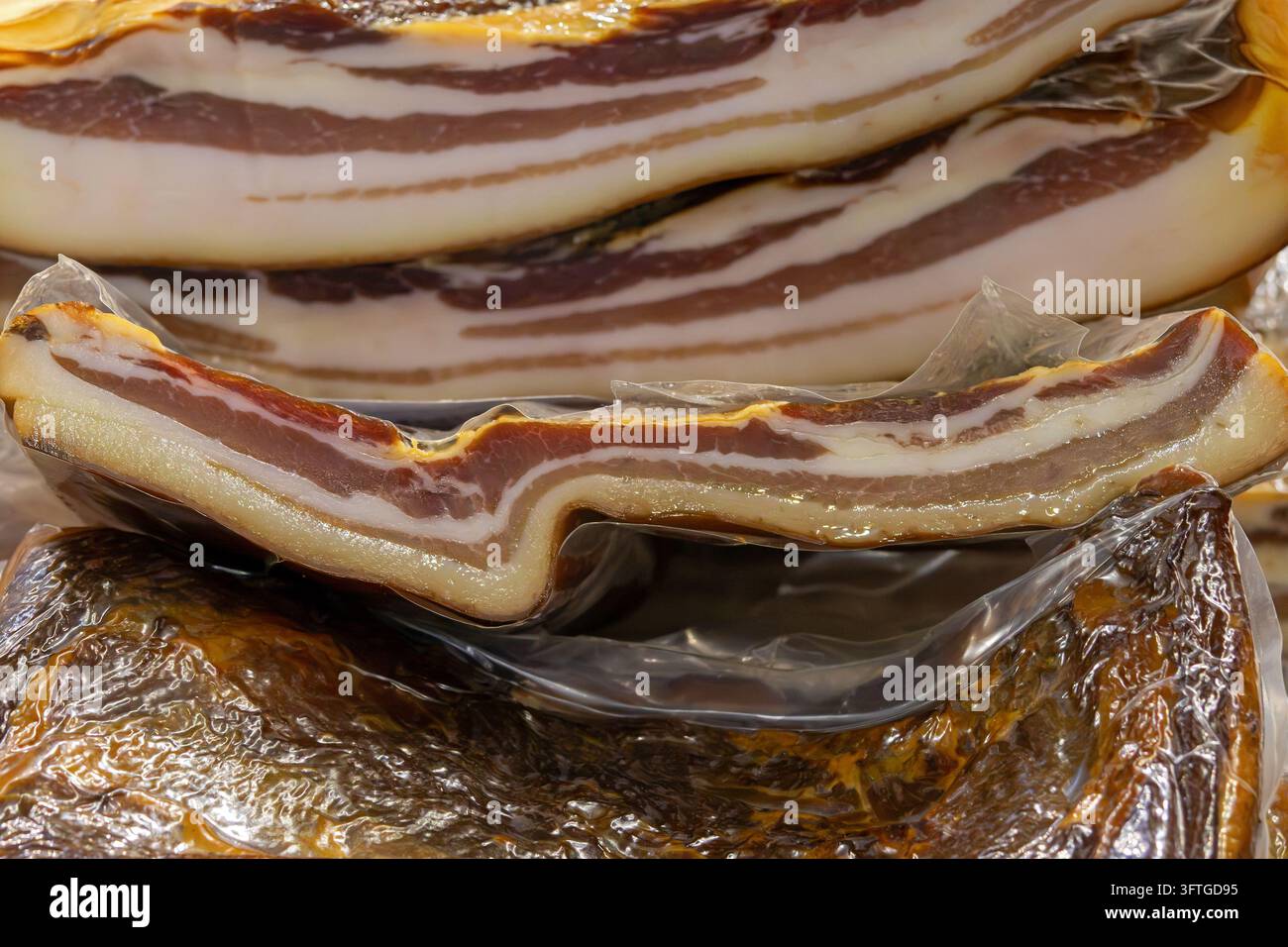 Organische hausgemachte, gepökelte fettige Schweinebacon-Fleischdelikatesse in der Balkanregion, die draußen auf dem lokalen Markt verkauft wird Stockfoto