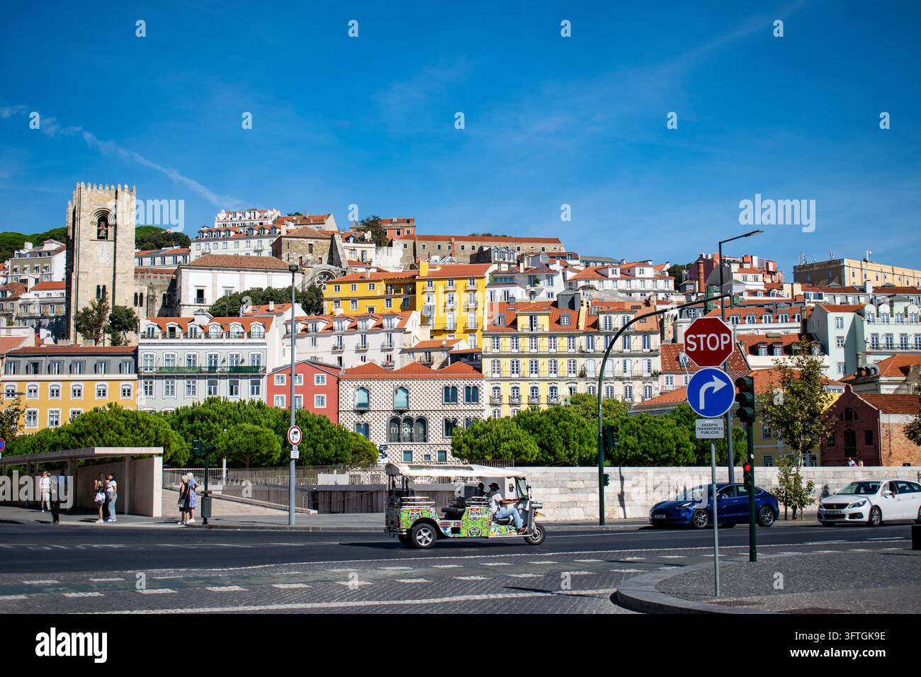 Lissabon Kathedrale und farbenfrohe Hügelgebäude mit Blick auf eine Straße mit einem Tourist-Tuk Tuk in Lissabon, Portugal. Stockfoto