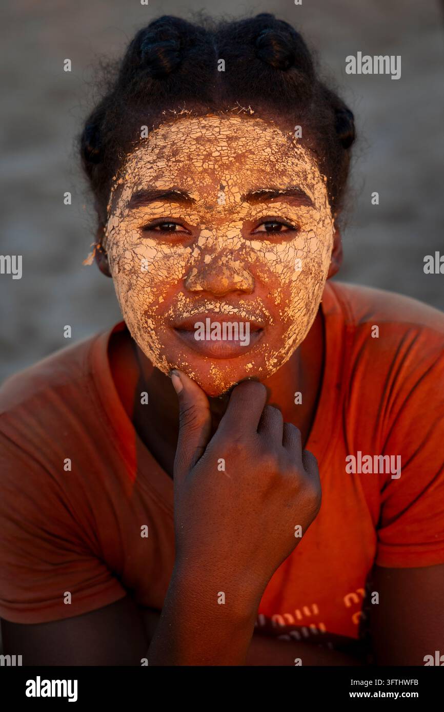 Eine junge Frau mit einer rissigen Ton-Schönheitsmaske stützt ihr Kinn auf die Hand bei Sonnenuntergang, Menabe, Tsiribihina, Madagaskar Stockfoto
