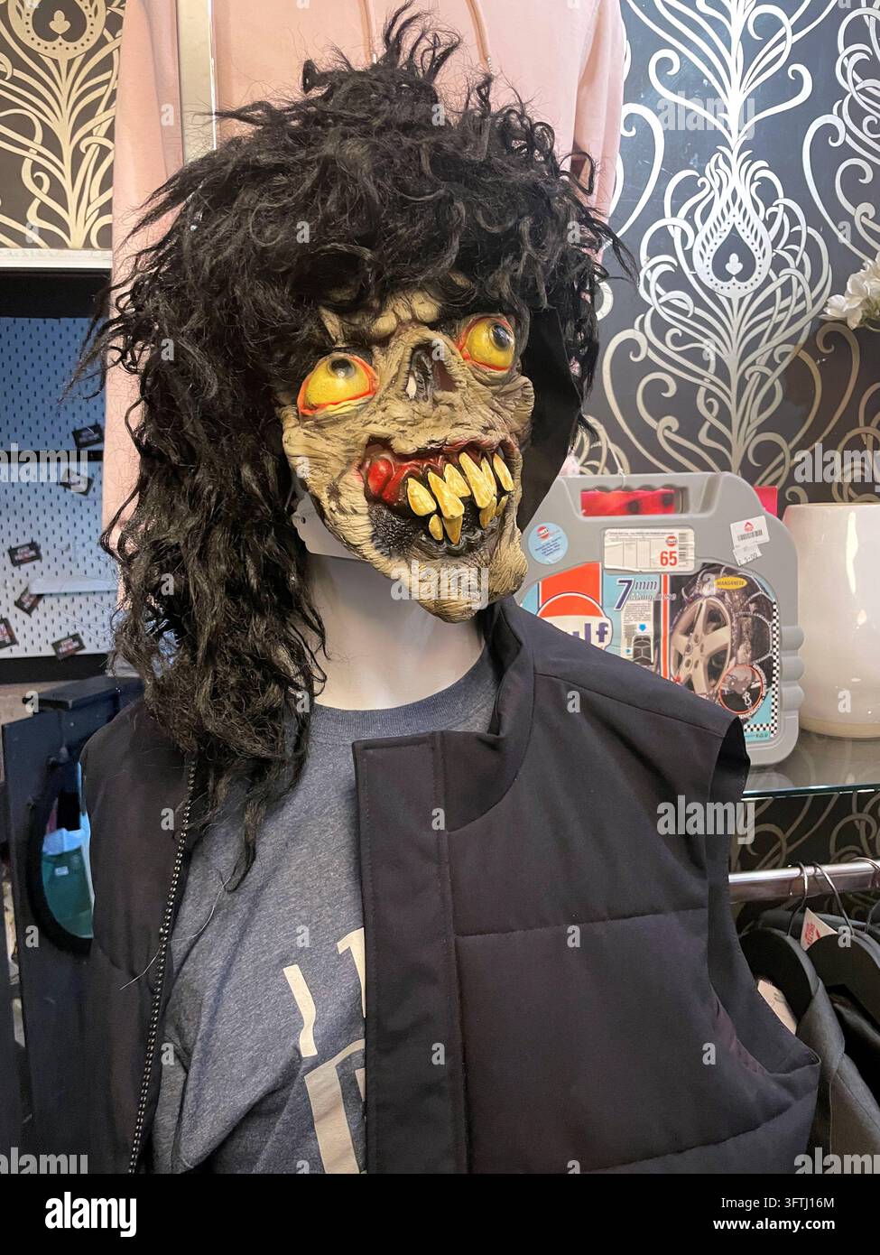 Gruselige Halloween-Maske zum Verkauf im örtlichen Wohltätigkeitsladen, UK - Smartphone-aufgenommenes Stockfoto