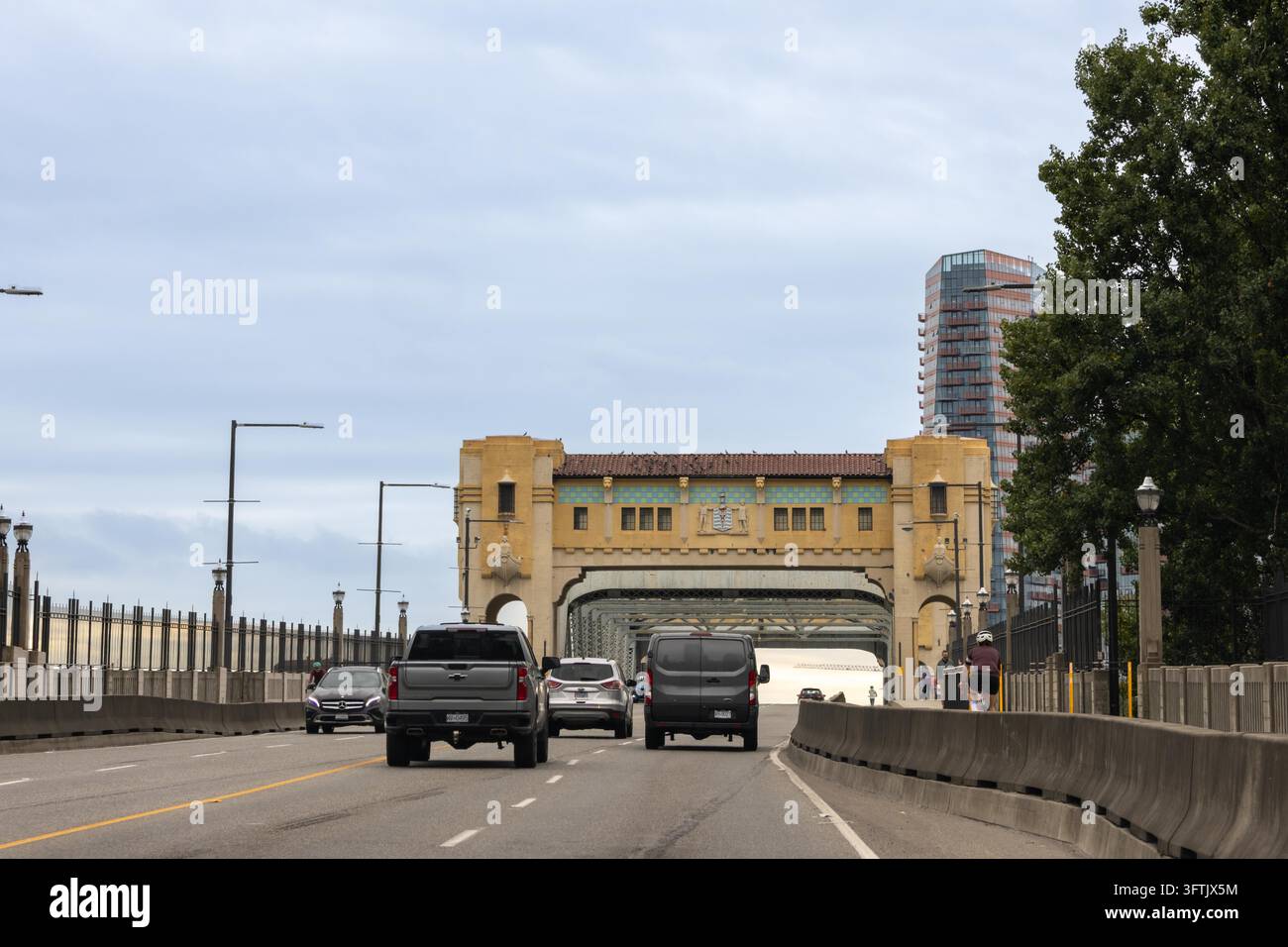 Vancouver, Kanada – 7. September 2026: Horizontale Augenhöhe-Aufnahme von Autos und einem Radfahrer, die über die Zufahrt zur Burrard Bridge in Richtung des kunstvollen Kunstwerks fahren Stockfoto