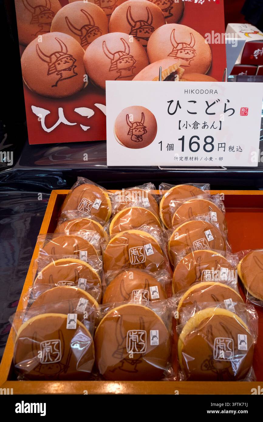Der Hikone-Stadt kawaii yurukyara japanische Maskottchen Hikonyan (Samurai-Katze) gestempelt auf frisch gebackenen Hikodora-Dorayaki-Bohnenpaste-Brötchen zum Verkauf in Japan. Stockfoto