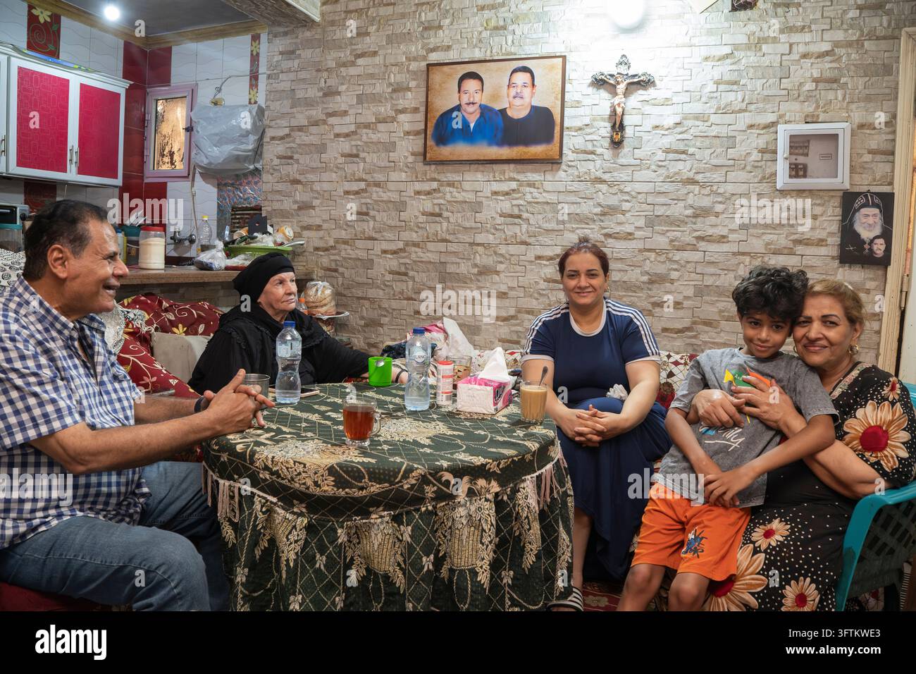 Das Moqattam-Viertel in Kairo, Ägypten. Das Moqattam-Viertel in Kairo, Ägypten. Eine Familie versammelt sich in ihrem Wohnzimmer um einen Tisch, unter dem Stockfoto