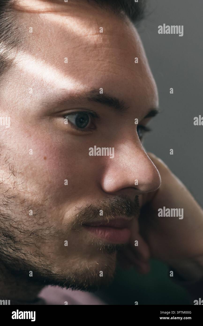 Nahaufnahme eines nachdenklichen Mannes im Schatten Stockfoto
