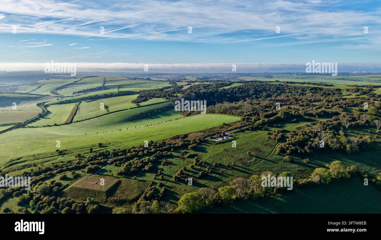 Luftbild-Drohnenaufnahme von patchwerkartigen grünen Feldern und bewaldeten Hügeln nahe Devils Dyke, West Sussex, England Stockfoto