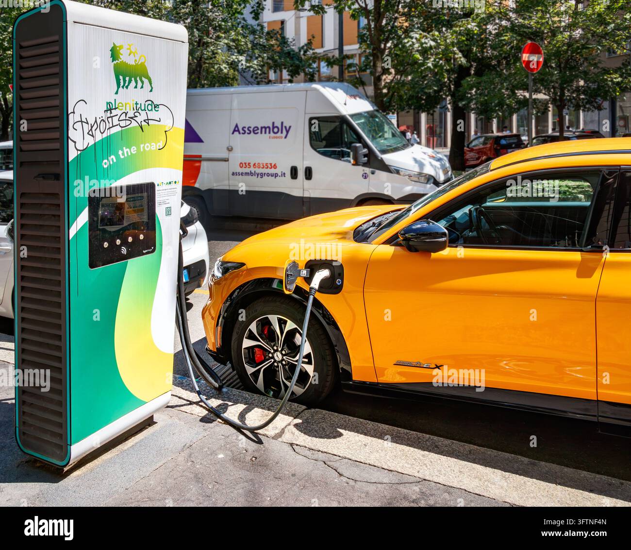Gelber Ford Mustang Mach-E rast an der Plenitude-Eni-Tankstelle entlang der Stadtstraße in Mailand, Italien Stockfoto