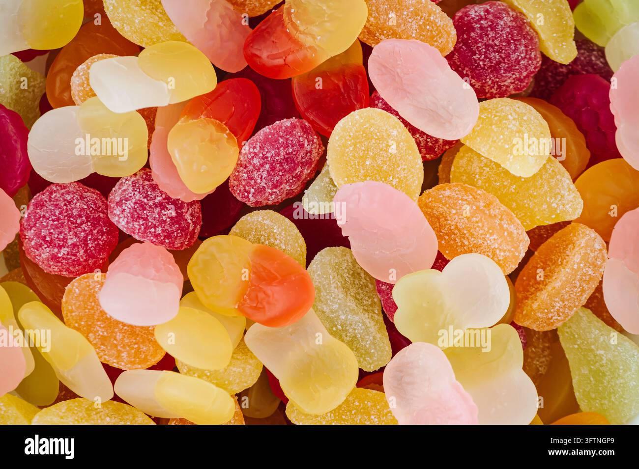 Kreativer Hintergrund aus Gummibärchen. Minimales trendiges Gummies-Konzept. Ästhetischer Hintergrund mit Gelee-Süßigkeiten. Buntes Flat Lay. Blick von oben. Stockfoto
