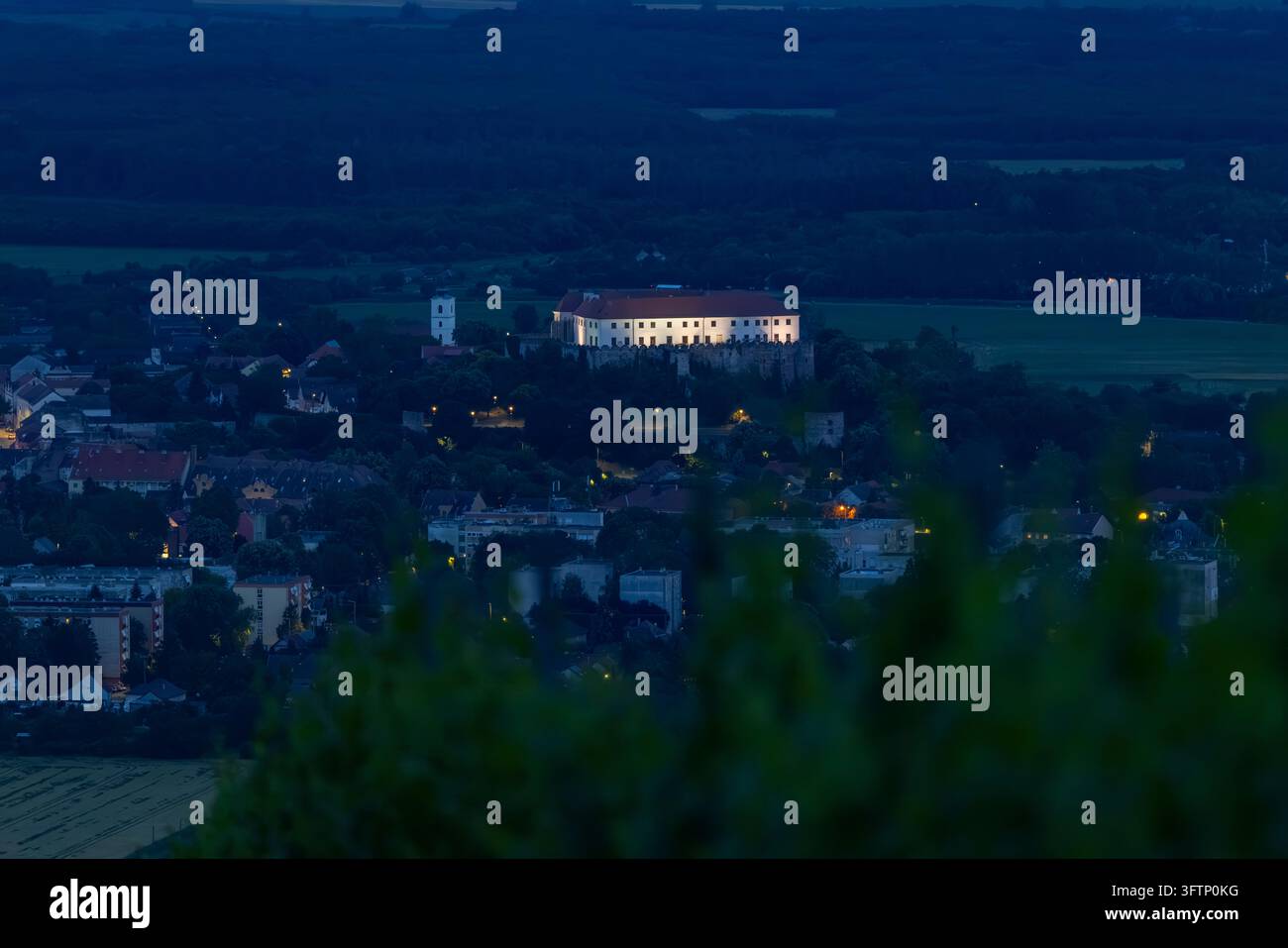 Schloss und Stadt leuchten bei Sonnenuntergang in einer Panoramicaufnahme Stockfoto
