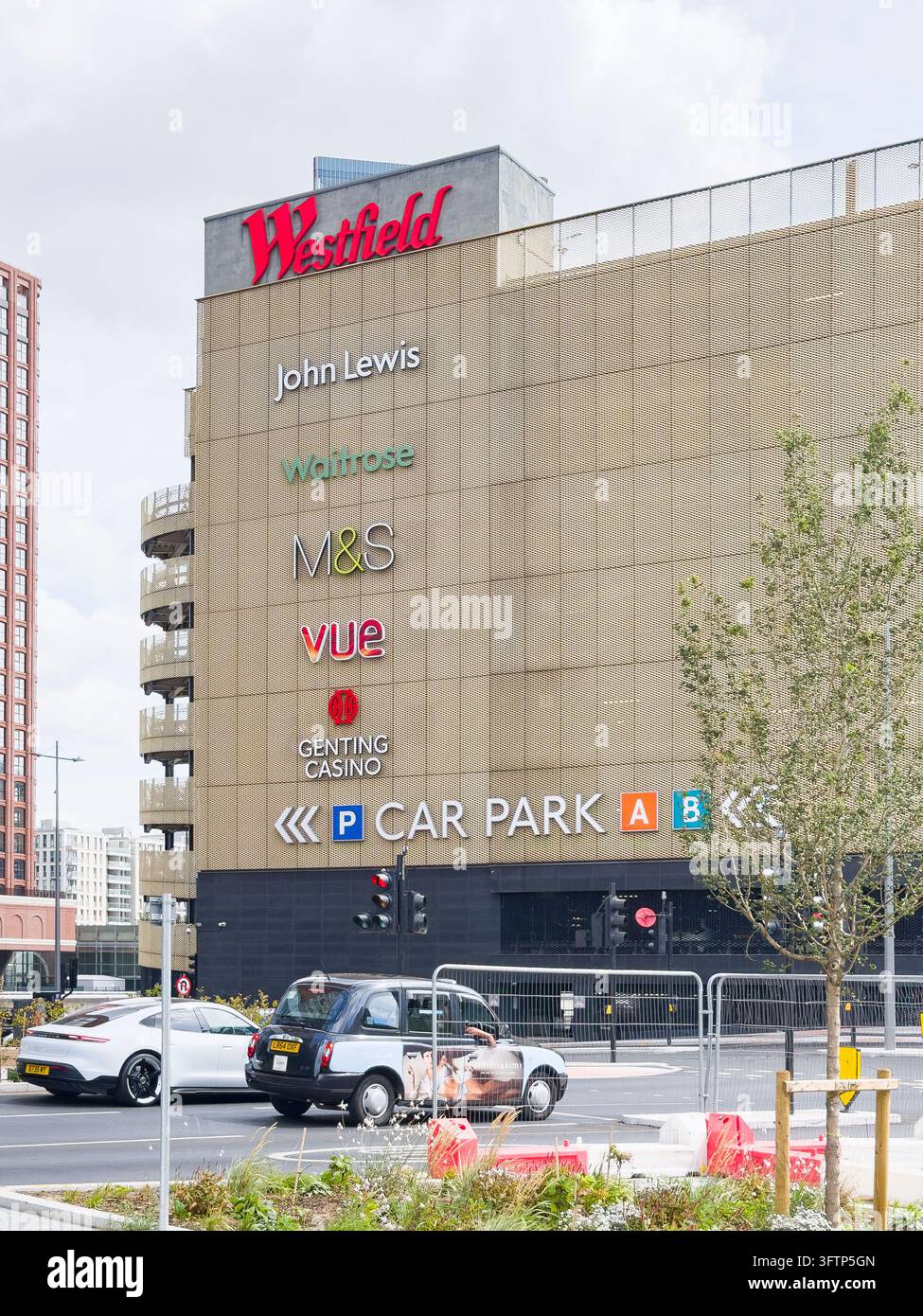 Westfield Stratford City Einkaufszentrum Gebäudeaußenansicht und Parkplatz in London mit Autos an der Kreuzung Stockfoto