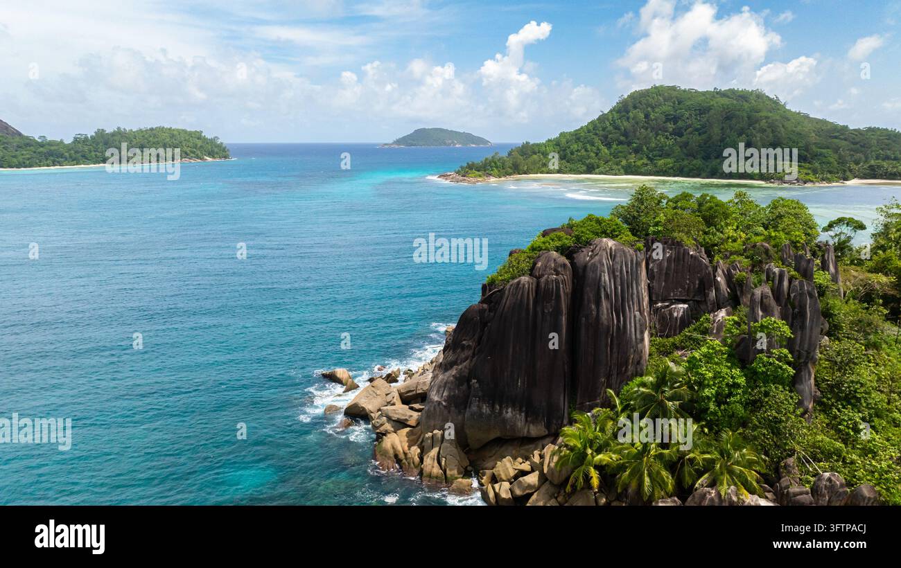 Sandstrände, türkisfarbenes Wasser und üppige Vegetation unter tropischen Inseln. Seychellen, Mahé. Stockfoto