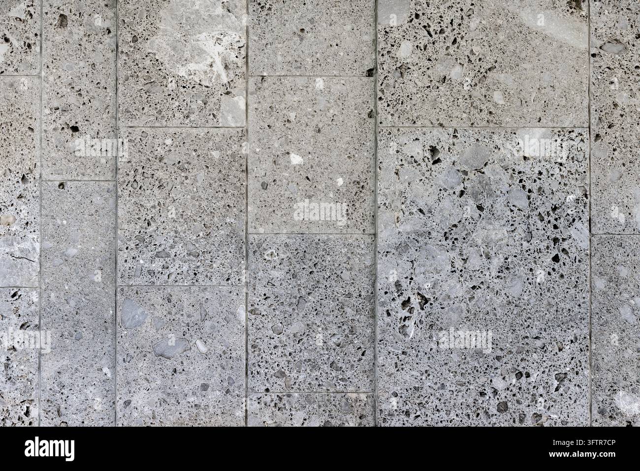 Graue poröse Travertinstein-Fliesenwand-Textur-Hintergrund Stockfoto