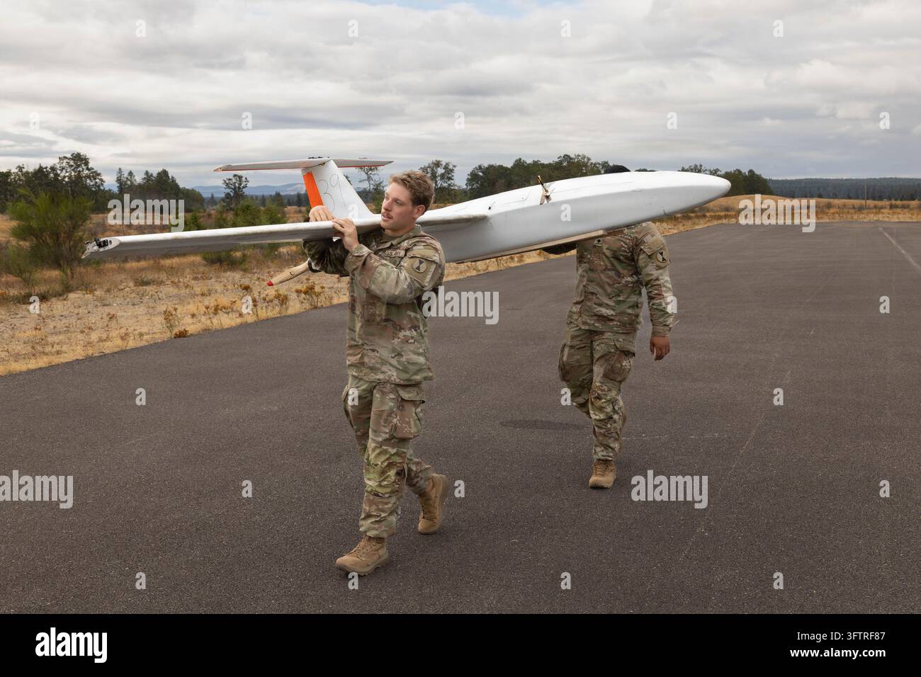 Tacoma, Vereinigte Staaten von Amerika. 27. August 2026. Soldaten der U.S. Army der 7. Infanteriedivision (Multi-Domain Command - Pacific) tragen eine Outlaw G2-Drohne nach der Landung während der Flugausbildung und Qualifikation im Rahmen der Übung Bayonet Thrust IV am 27. August 2026 in der Joint Base Lewis-McChord, Washington. Credit: SSgt Christian Morton/U.S. Army Photo/Alamy Live News Stockfoto