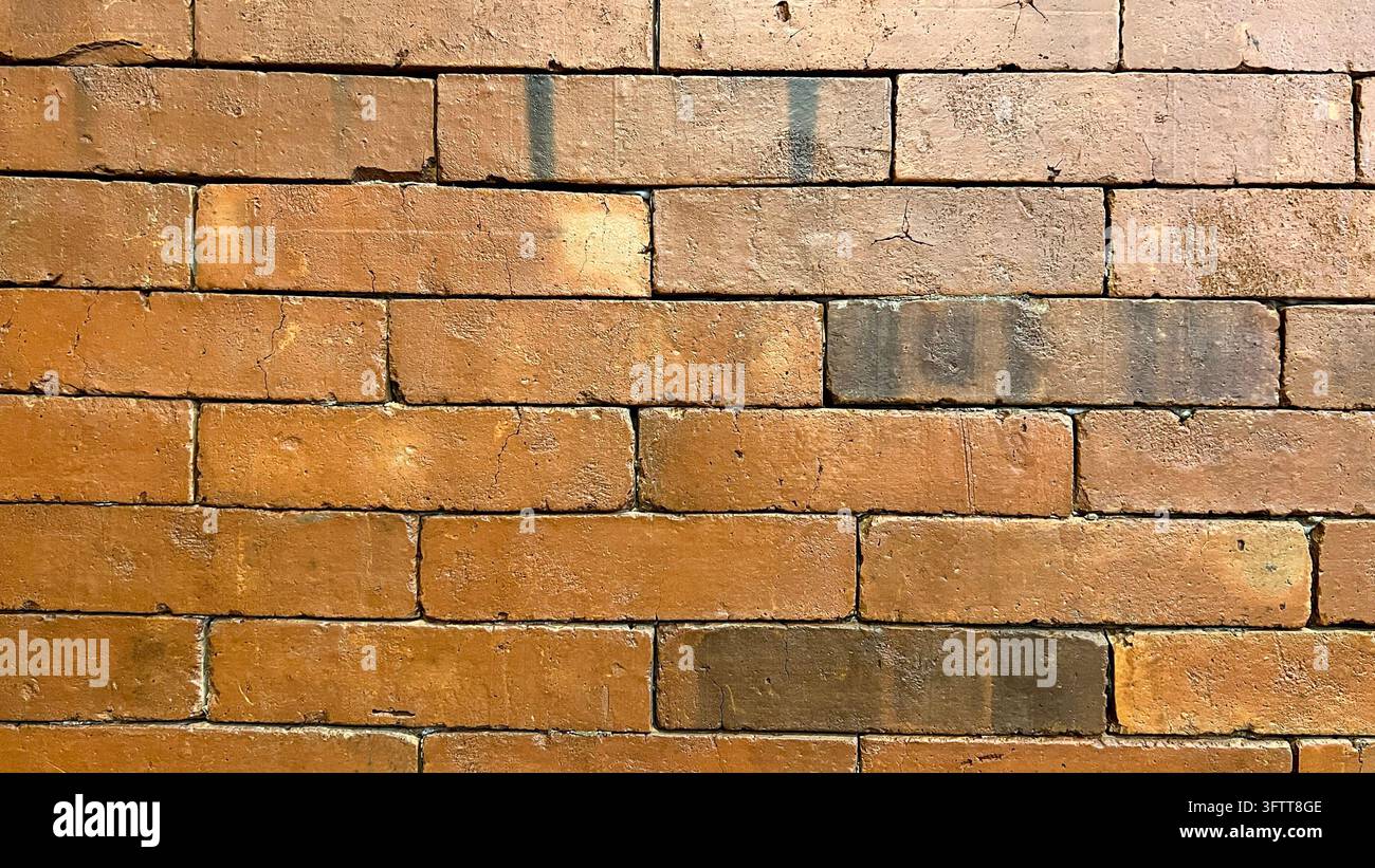 Roter und orangefarbener Ziegelwandtextur mit Laufender-Bindung-Maurermuster Stockfoto