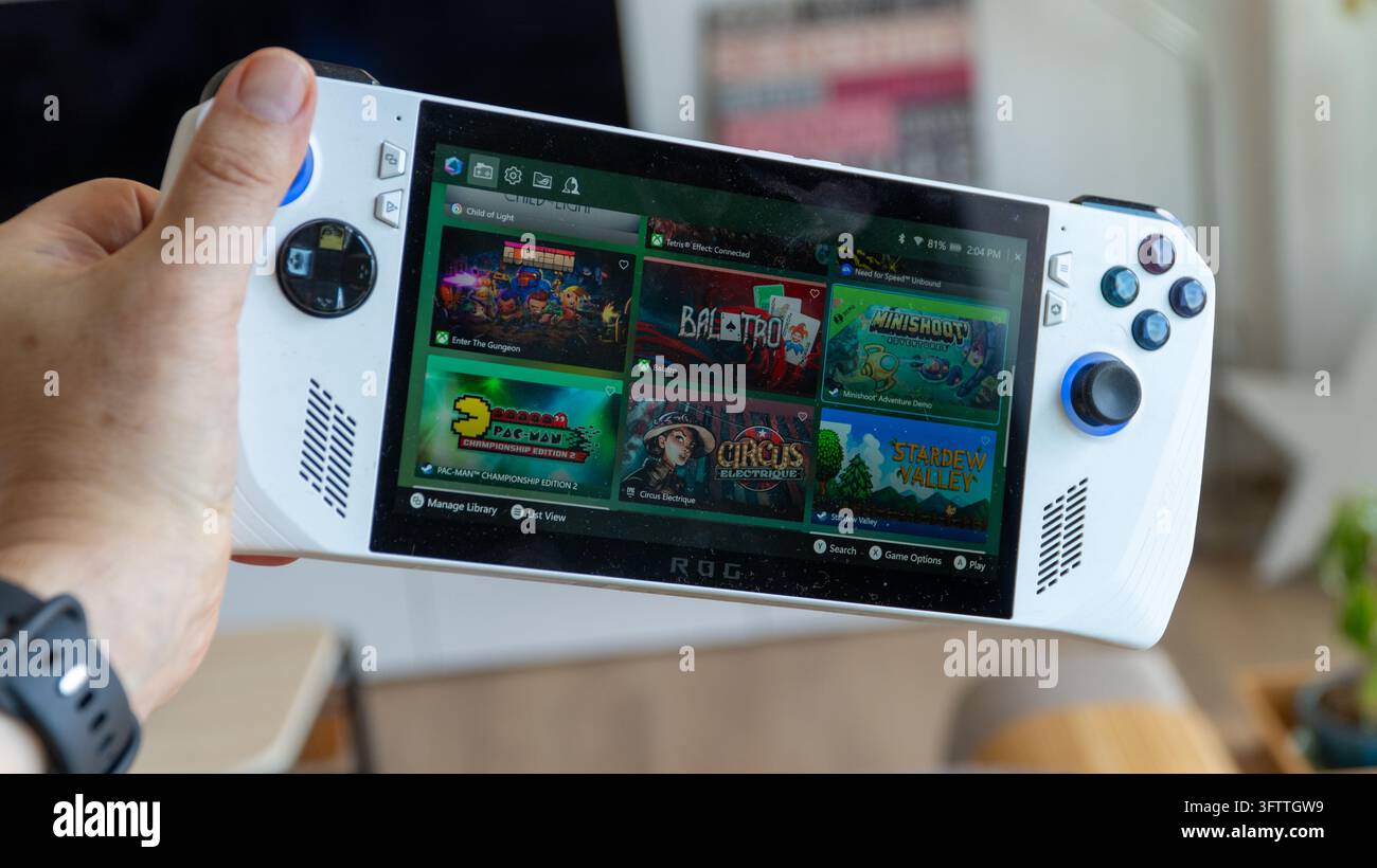Türkei – 7. Oktober 2026: Asus ROG Ally tragbarer Gaming-PC in Weiß, in einer Hand, mit Spiel-Covern auf dem Display und blau beleuchteten Joysticks Stockfoto