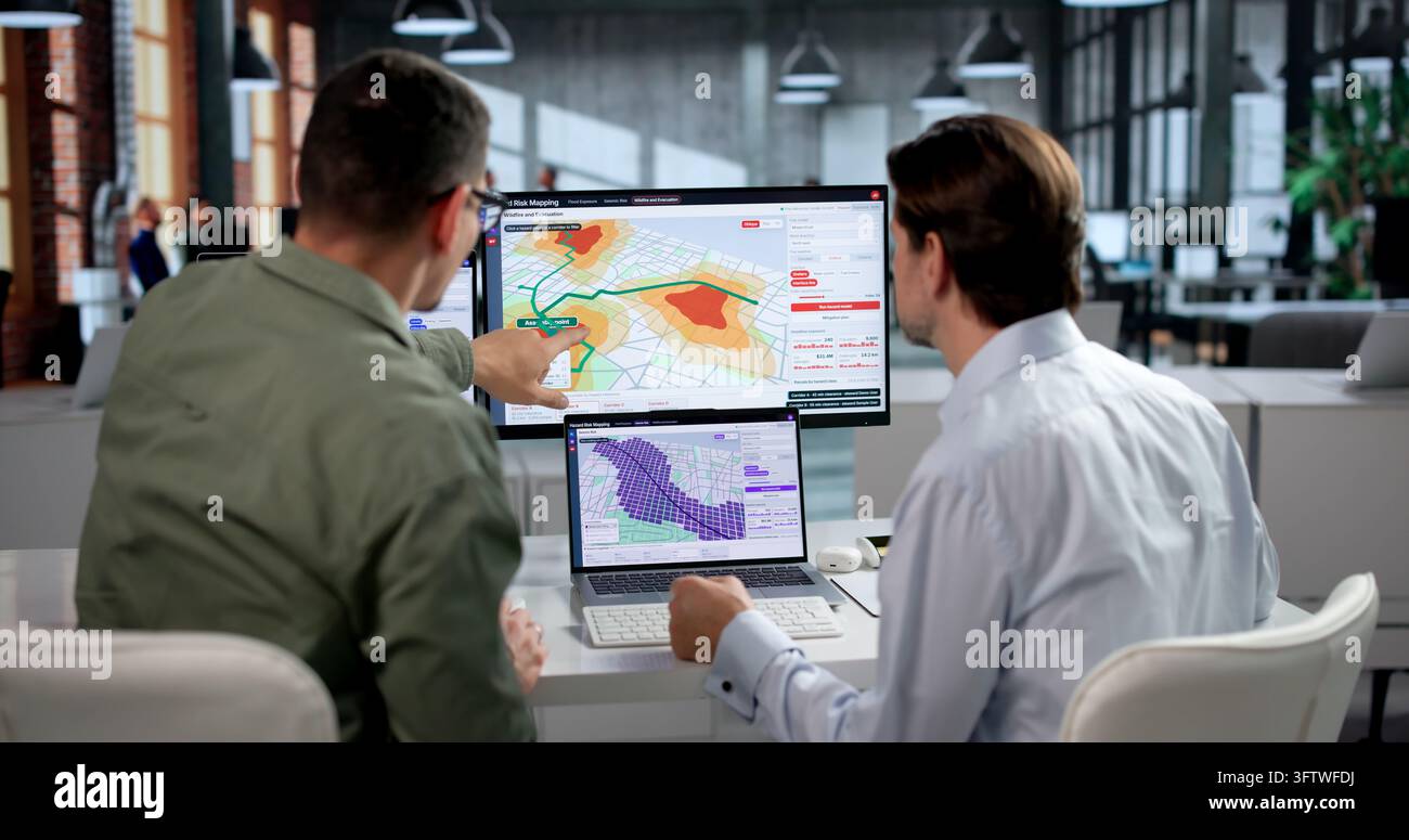 Geospatialer Analyst und Kollege nutzen Software zur Analyse von Hochwasserrisikodaten. Stockfoto
