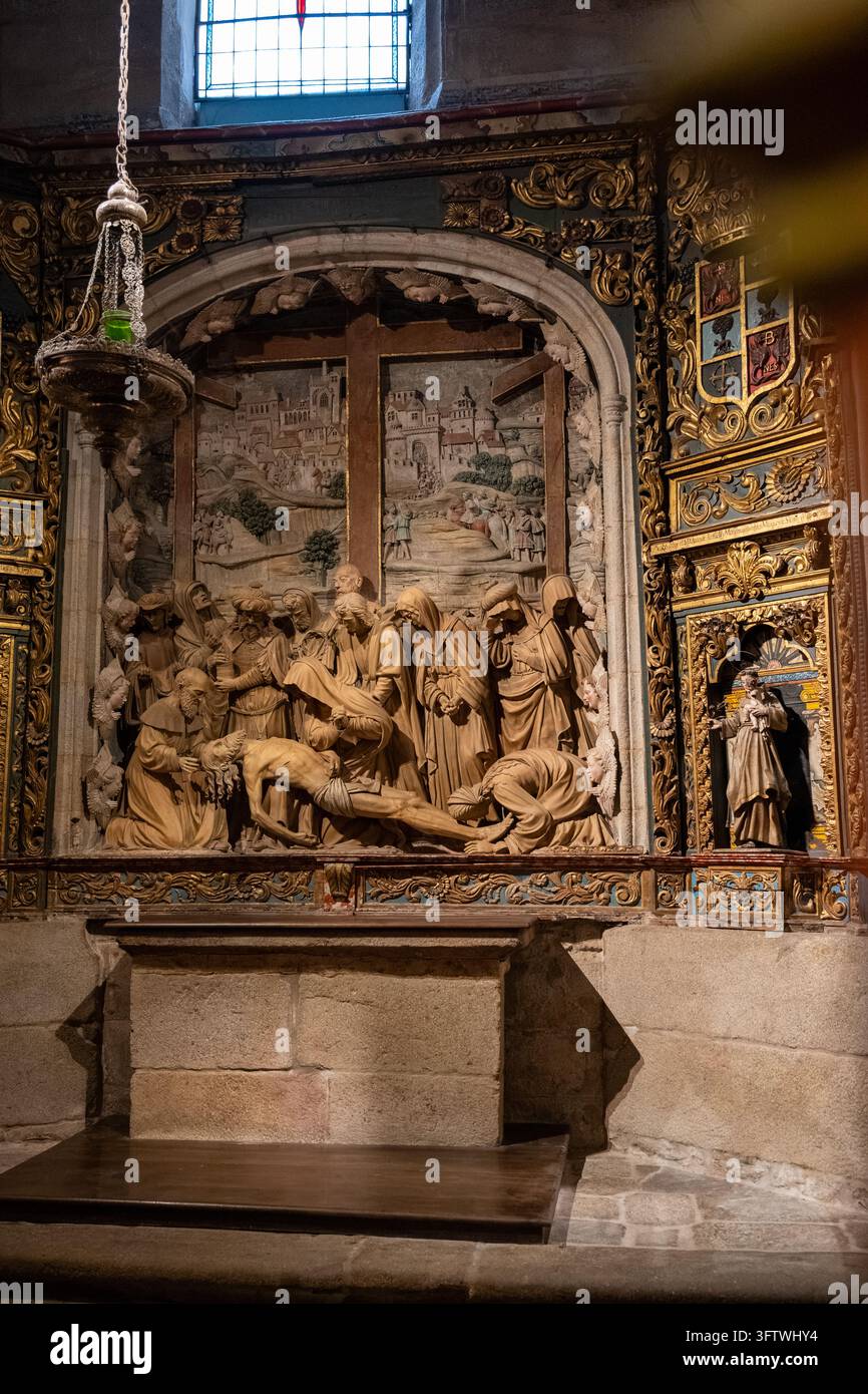 Bildhauerisches Relief, das das Herabsteigen vom Kreuz darstellt, umgeben von vergoldeten Dekorationen in einer Kapelle der Kathedrale von Santiago. Stockfoto