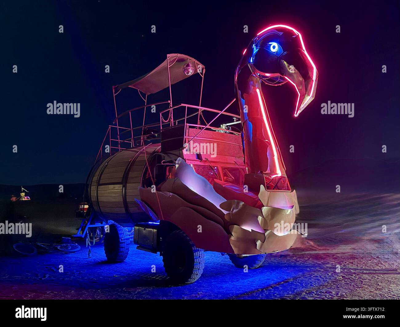 Rosa Vogel-Mutant-Fahrzeug leuchtend in der Wüste, fotografiert bei AfrikaBurn im Tankwa Karoo, Nordkap, Südafrika. - Smartphone-aufgenommenes Stockfoto