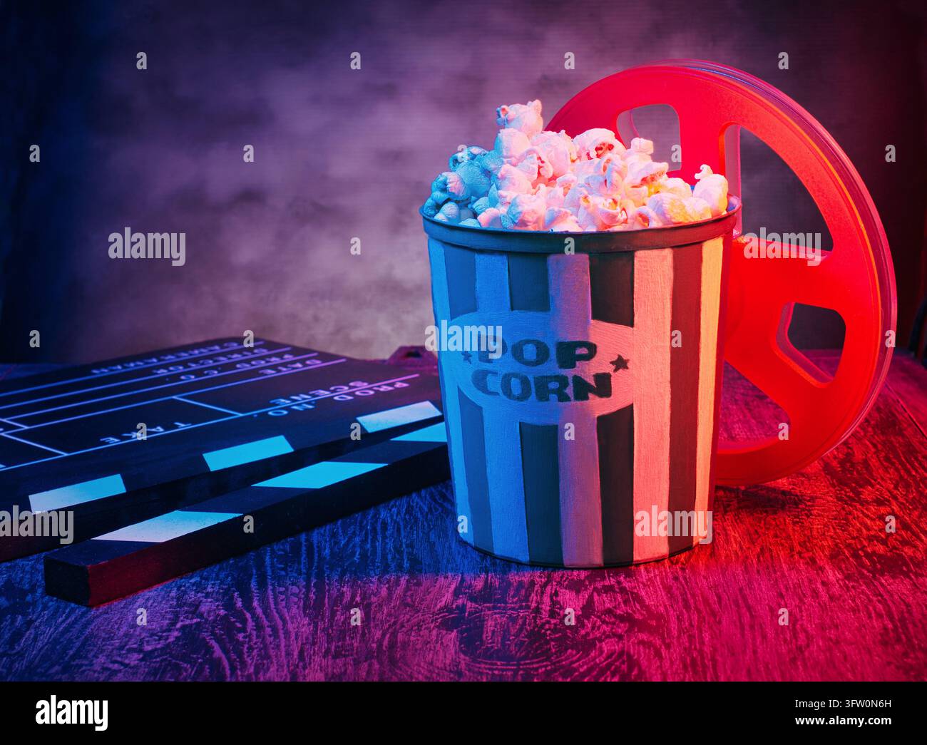 Kinofilm-Konzept-Hintergrund mit einer Popcorn-Tüte, 3D-Brille, einem Klappebrett und einer Filmrolle. Vorlage für einen Filmabend, Tischfotografie Stockfoto