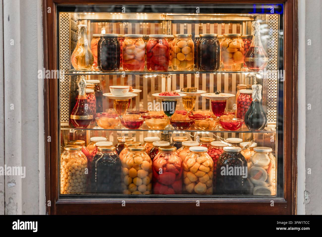 Türkei, Istanbul 2025 10 03: Augenhöhe-Bild einer Schaufensterauslage, gefüllt mit Gläsern voller farbenfroher traditioneller türkischer Gurken, Konserven und Fer Stockfoto